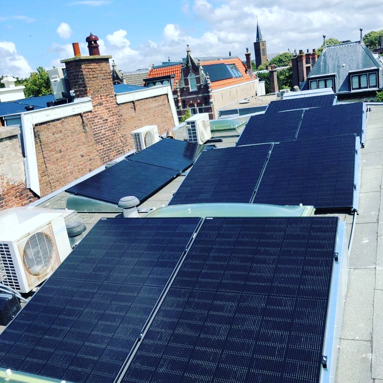 Monteurs van GS Solar installeren zonnepanelen via een steiger op een schuin dak