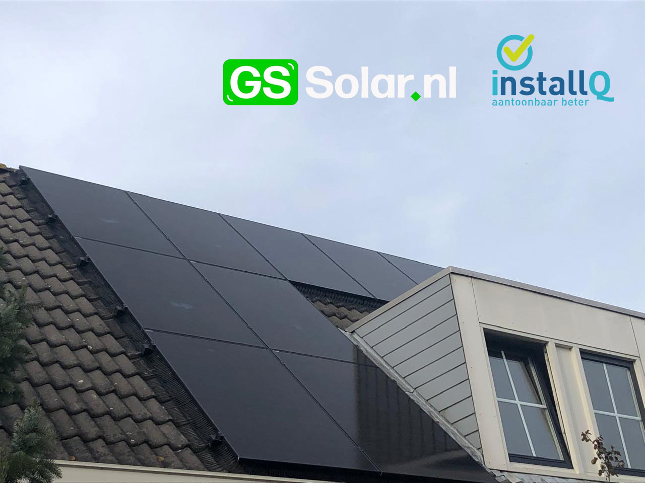 Zwarte zonnepanelen rond een dakkapel op een schuin pannendak