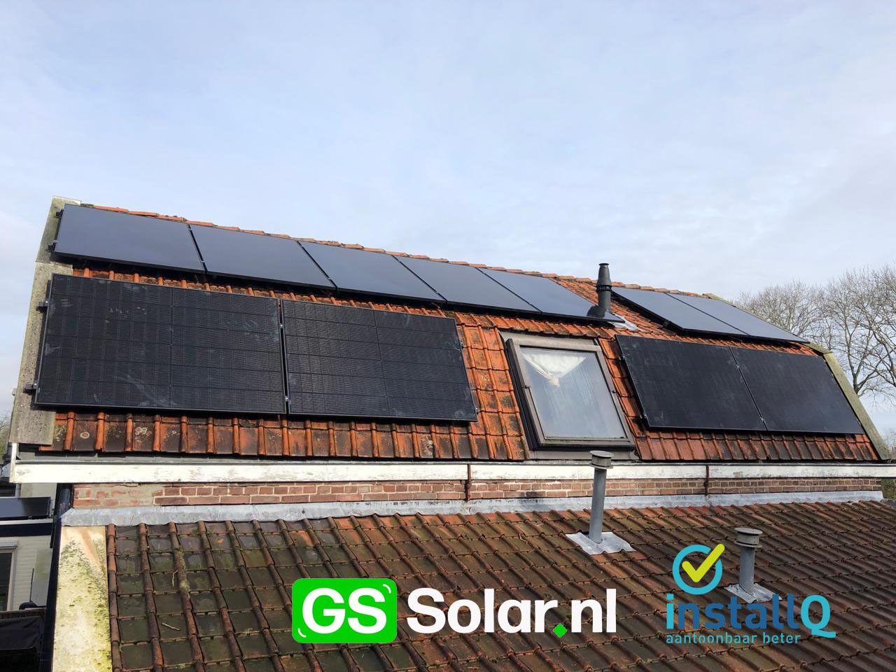 Zwarte zonnepanelen rond een dakraam op een bestaand rood pannendak